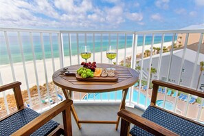 A balcony with a table set for a meal, overlooking a beach and pool. - TIDEWATER 4th FLOOR - SKIP ELEVATORS! Quiet End Unit, VIEWS, walk to Pier Park! (Panama City Beach)