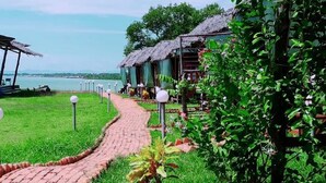 A pathway leading to thatched-roof huts with a view of the water. - 9 Huts on a Hill (Kudat)