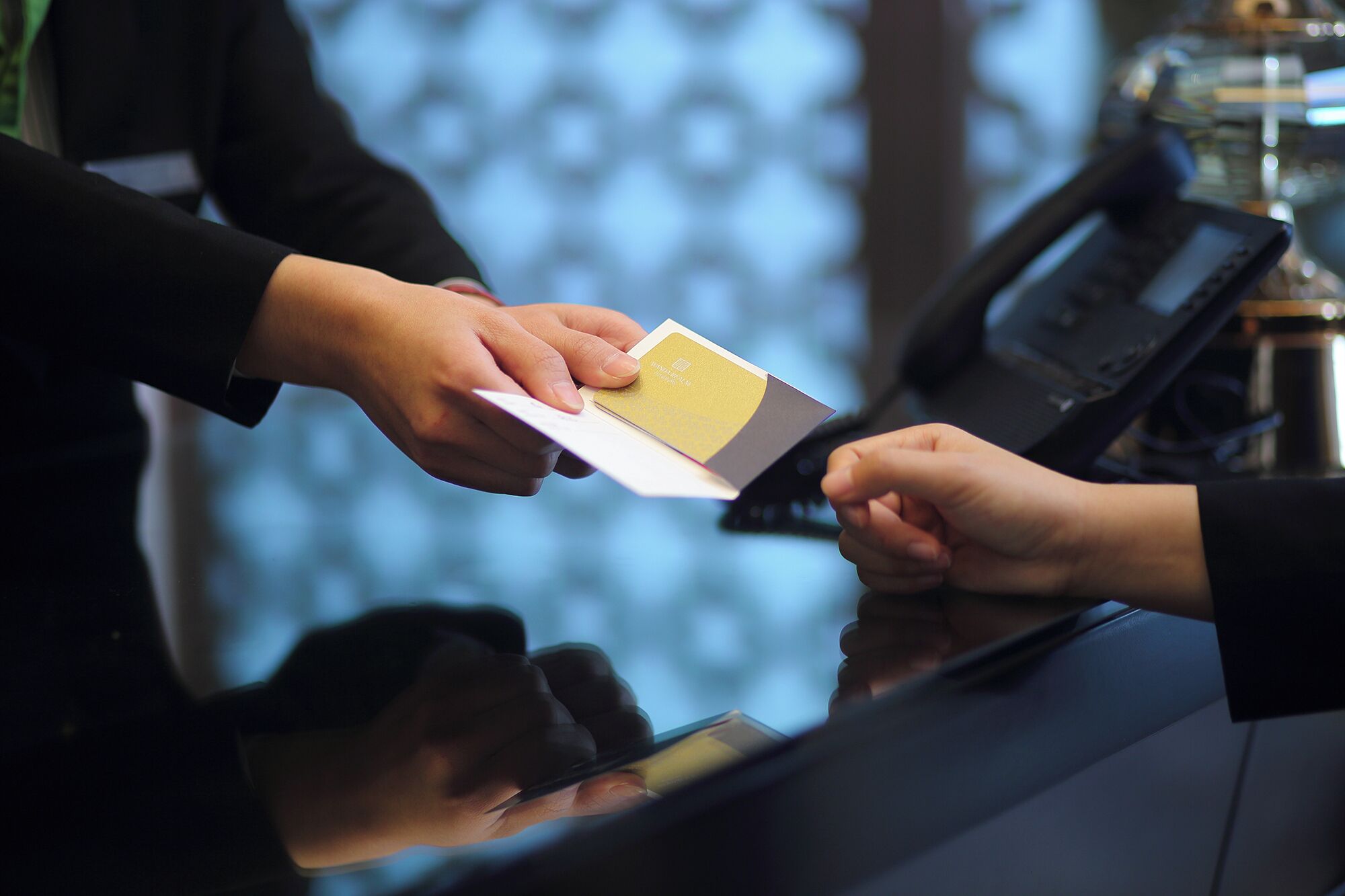 A person handing over a card to a machine, likely for a transaction.