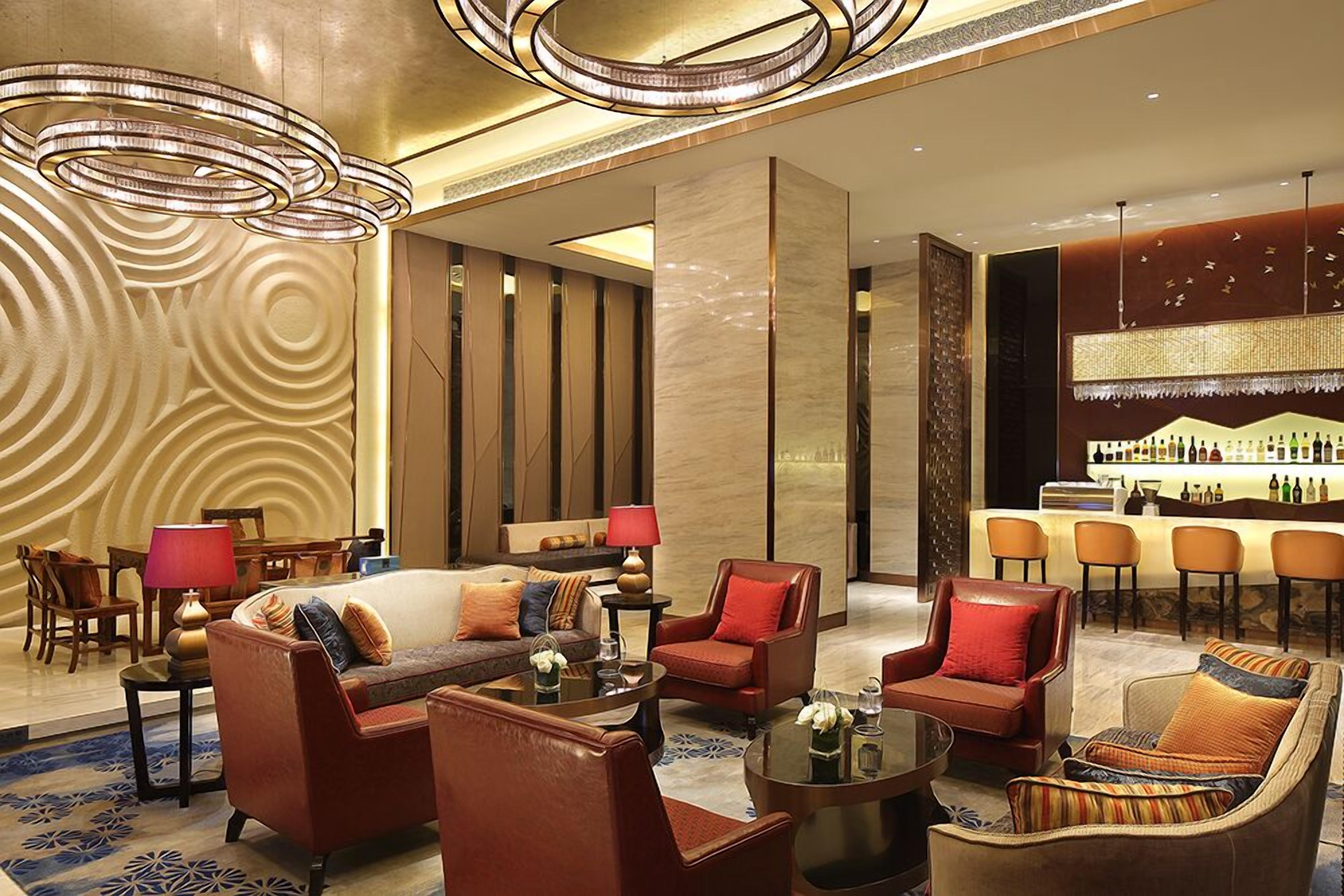 A spacious lobby with leather sofas, a bar area, and a patterned wall.