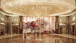 A spacious lobby with a high ceiling, a large chandelier, and a mural of red foliage. - Wanda Realm Taian (Tai'an)