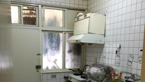 A compact kitchen with white tiled walls, a window with a view, and basic amenities like a sink and stove. - Star House 2 (Taipei)