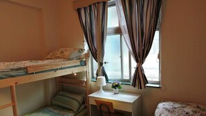A dormitory room with bunk beds, a desk, and a chair. - Star House 2 (Taipei)