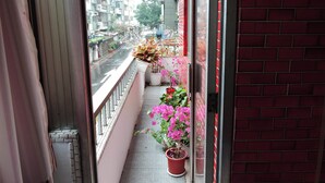 A balcony with potted plants and a view of a city street. - Star House 2 (Taipei)