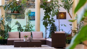Ein gemütliches Wohnzimmer mit einer Eckcouch, einem Couchtisch und mehreren Blumentöpfen.