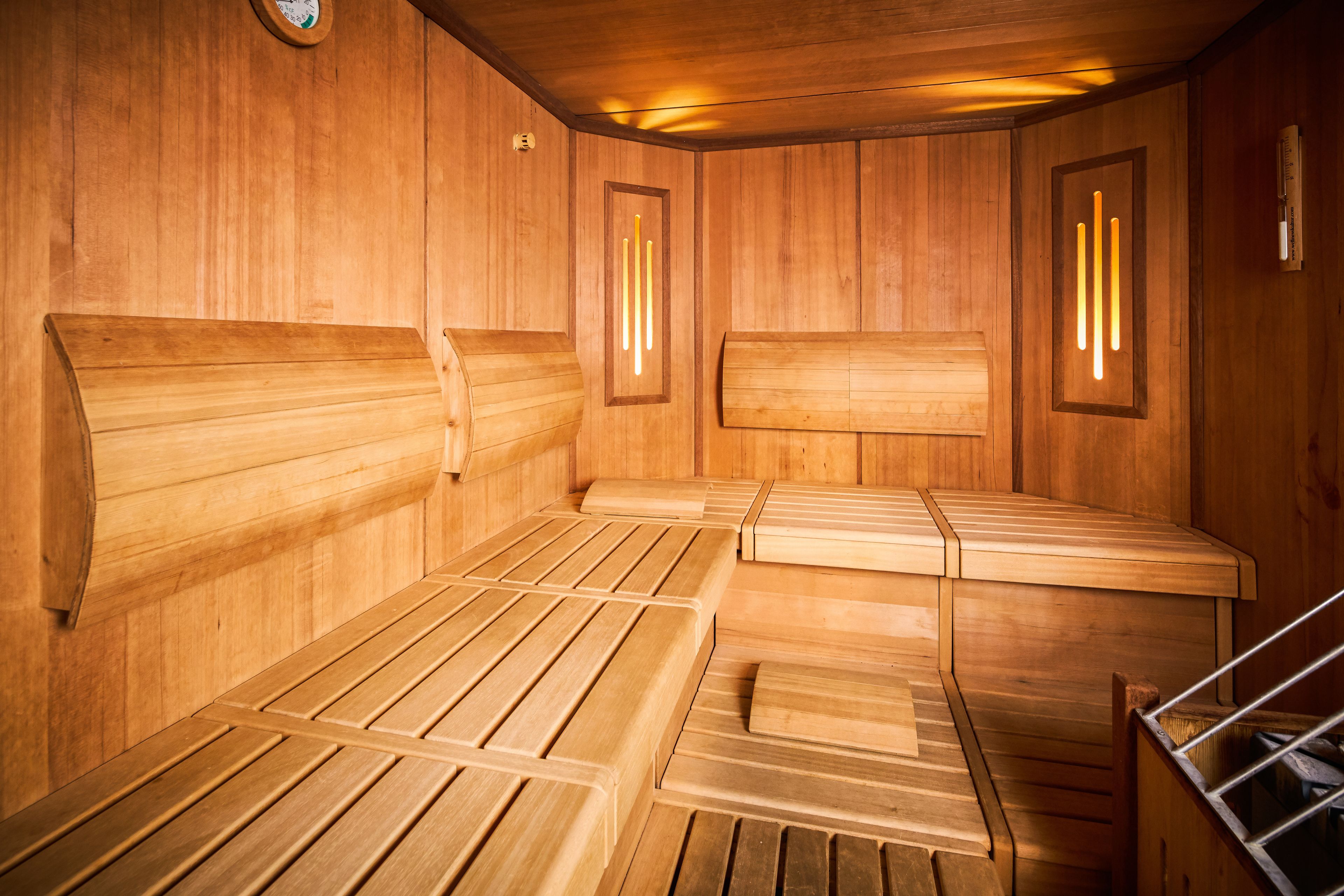 Un sauna avec des bancs en bois, des murs en bois et un plafond en bois.