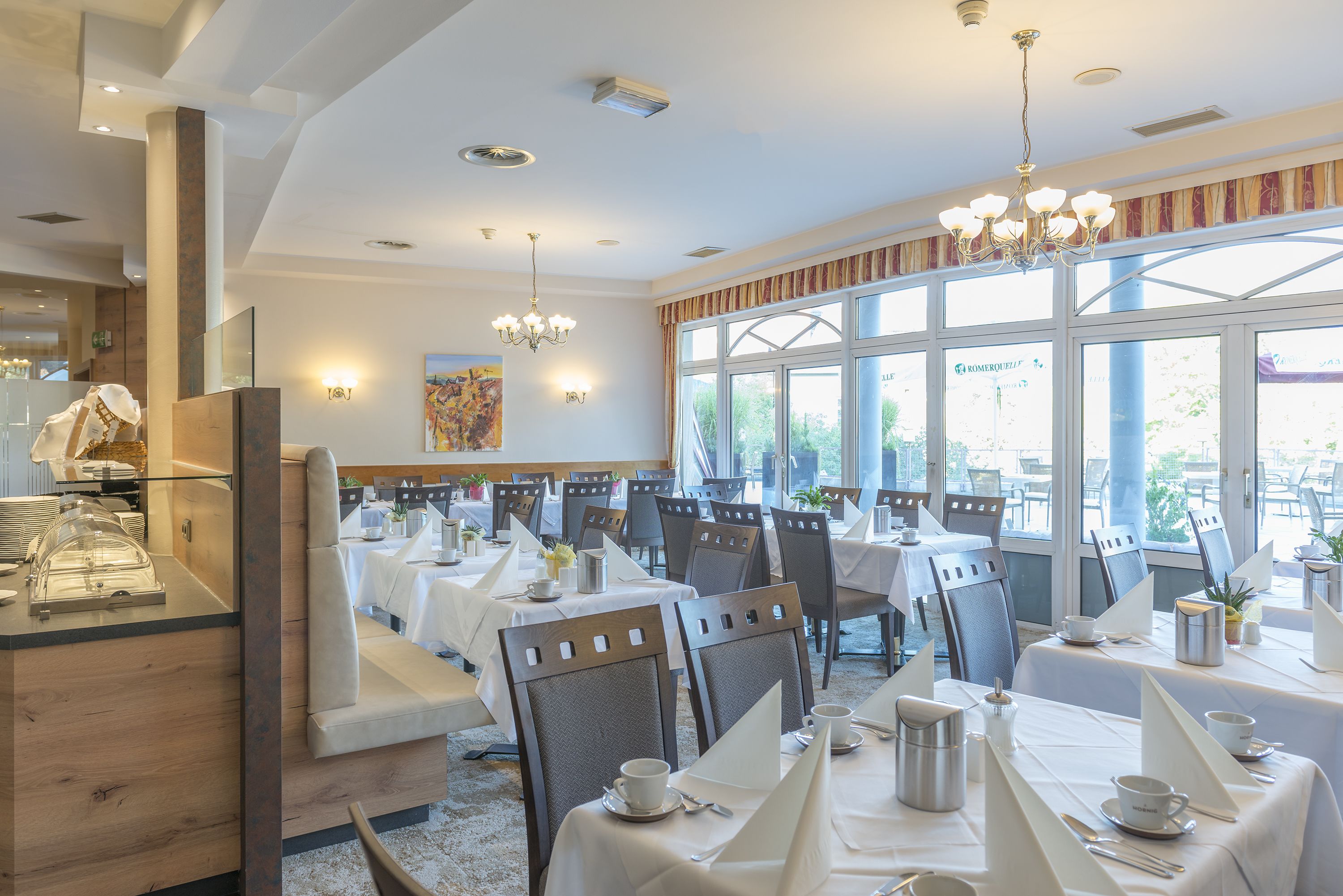 Un ristorante con diversi tavoli, sedie e un'area riservata al buffet.