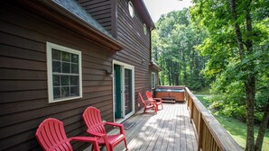 A wooden deck with red Adirondack chairs and a hot tub. - Secluded Mountain Haven in Seven Devils (Seven Devils)