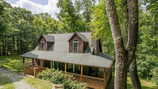 A cabin with a porch, a chimney, and a covered deck area. - Secluded Mountain Haven in Seven Devils (Seven Devils)