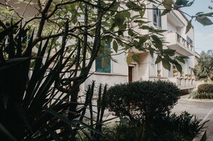Un edificio de varios pisos con balcones y plantas en macetas.