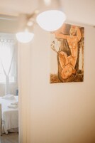 Una habitación con una cama, una silla y un cuadro en la pared.