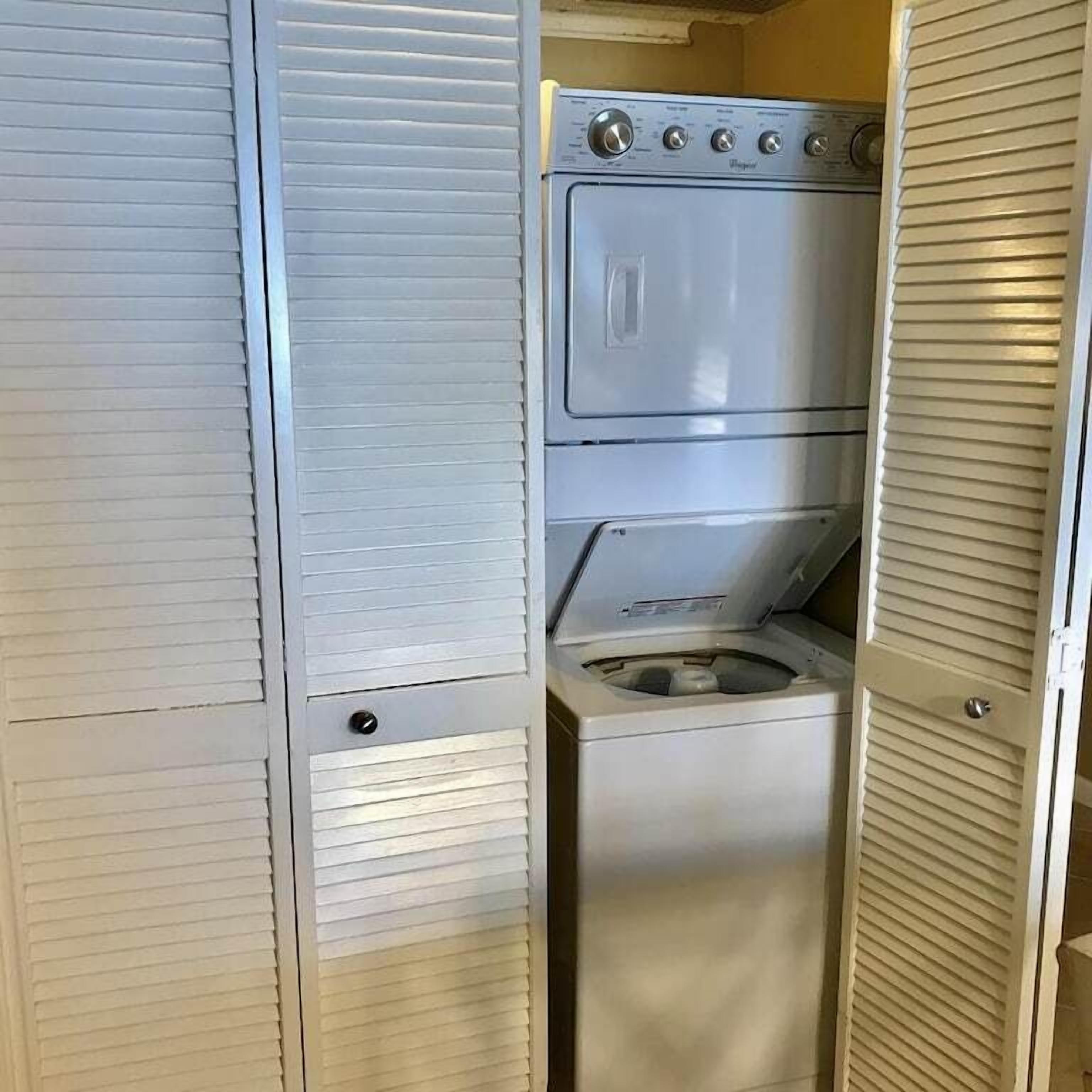 A compact laundry room with a front-loading washing machine and a dryer.