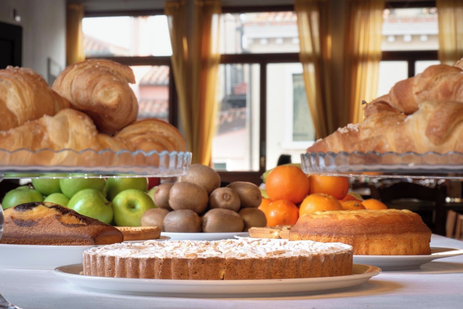 Un buffet proposant des pâtisseries, des fruits et un gâteau.