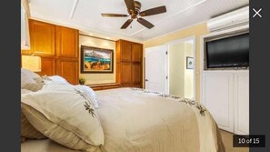 Relax in this inviting space with a large bed, ceiling fan, and wall-mounted TV.
