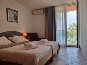 Dreibettzimmer, Balkon, Meerblick | Bügeleisen/Bügelbrett, Babybetten, WLAN, Bettwäsche