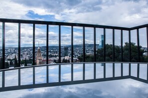 A balcony with a clear view of a cityscape, including buildings and a tower.