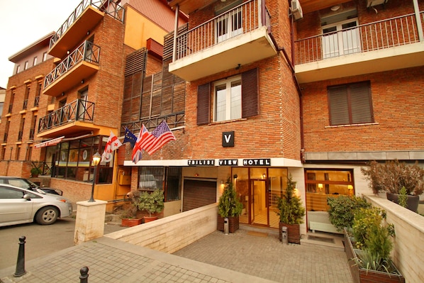 A hotel with a brick facade, multiple balconies, and a sign indicating it is the Tbilisi View Hotel.