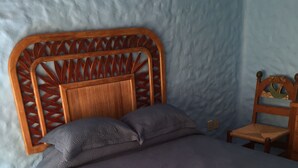 Un lit avec une tête de lit en bois et une couvre-lit matelassée bleue.