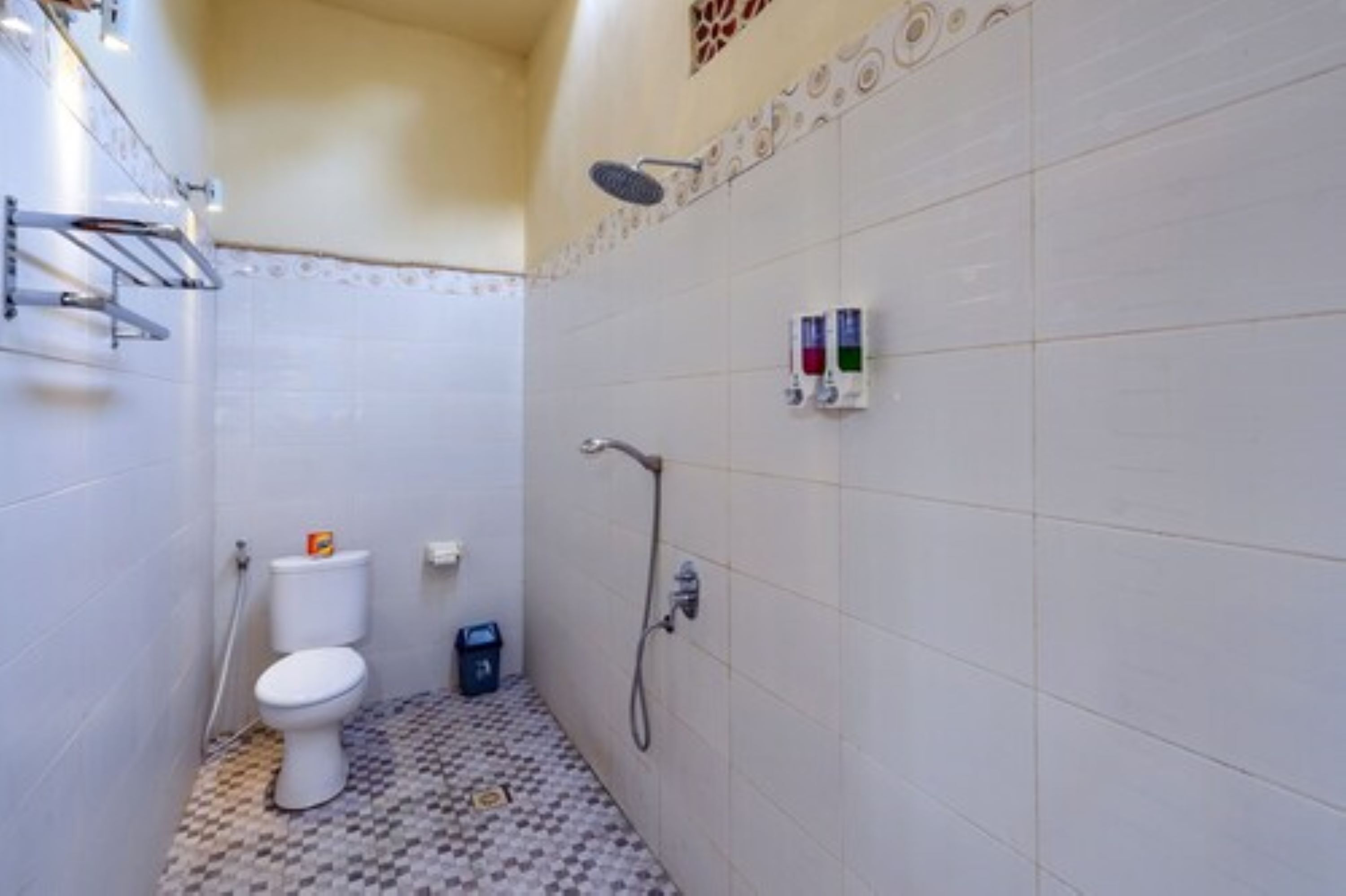 A small bathroom with a toilet, a shower, and a tiled floor.
