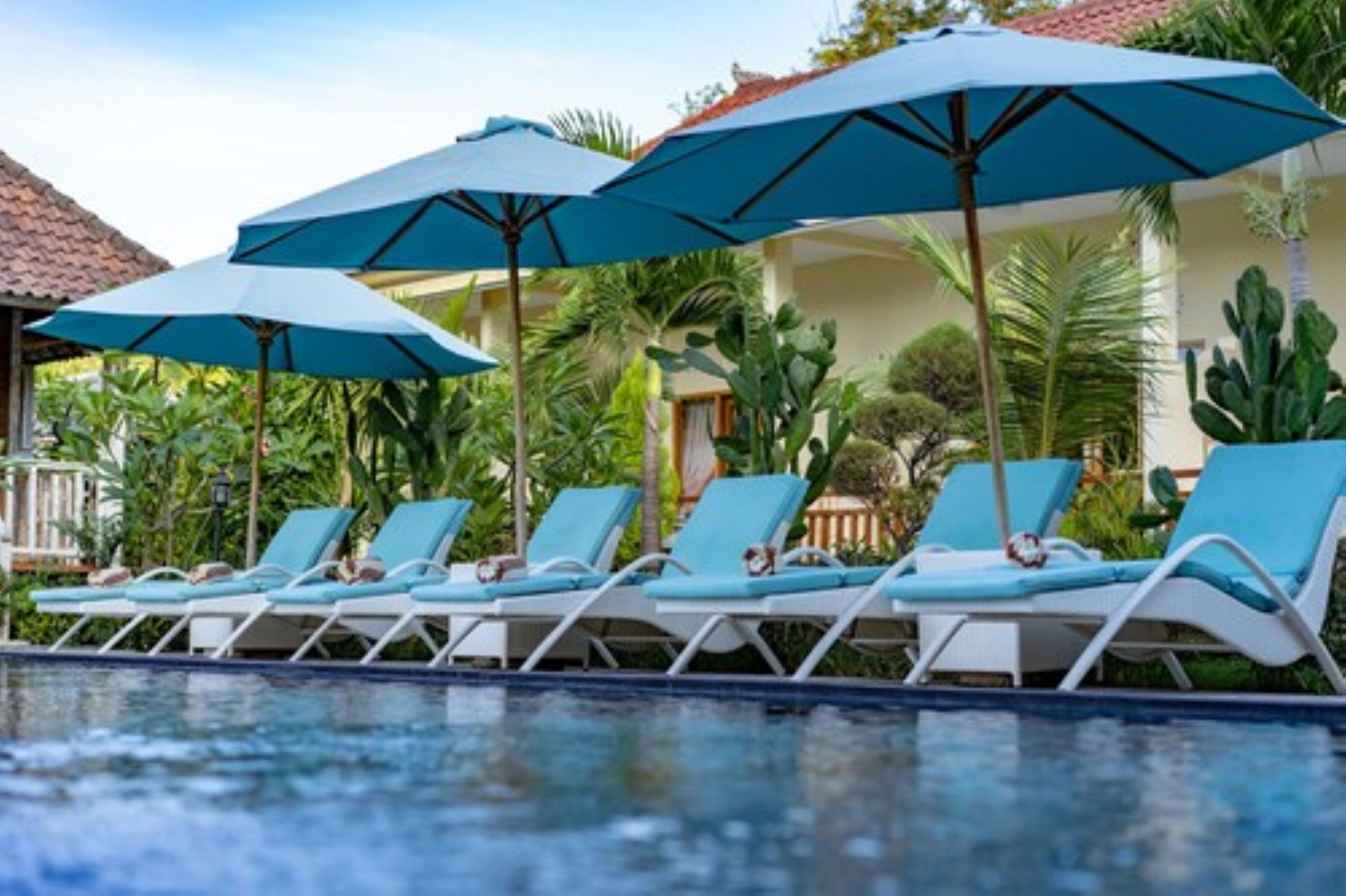 A poolside area with lounge chairs and umbrellas.
