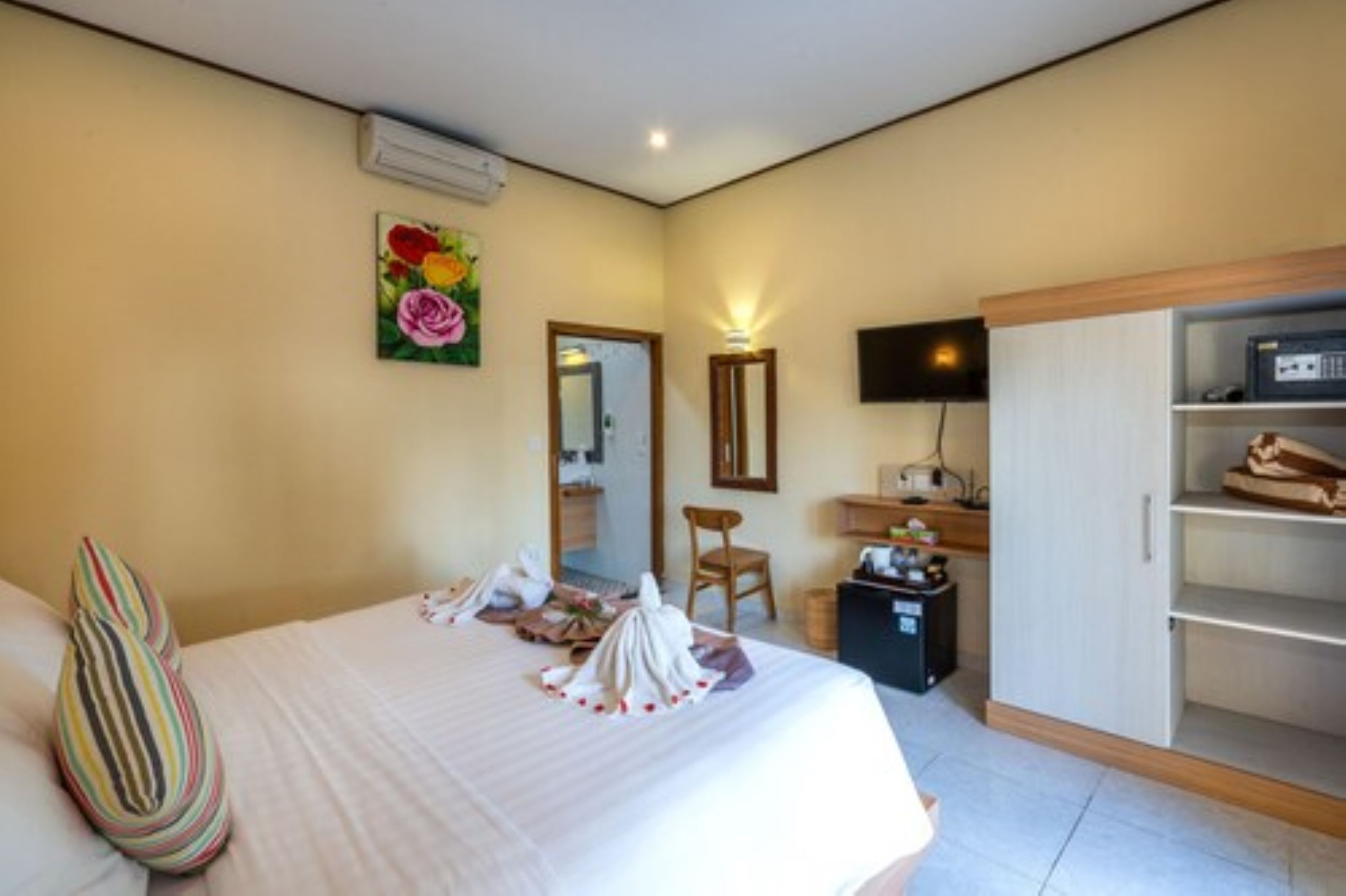 Une chambre d’hôtel équipée d’un lit, d’un bureau, d’une chaise, d’une télévision et d’une armoire.