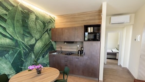 A modern kitchen with wooden cabinets, a built-in microwave, and a coffee maker. - Residence Alesi (Malcesine)