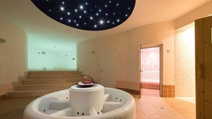 A spa area with a circular hot tub, a staircase, and a starry ceiling. - Residence Alesi (Malcesine)