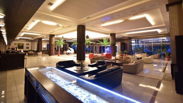 A spacious lobby with a central water feature, comfortable seating areas, and large windows providing views of the cityscape. - Saylamlar Hotel (Trabzon)