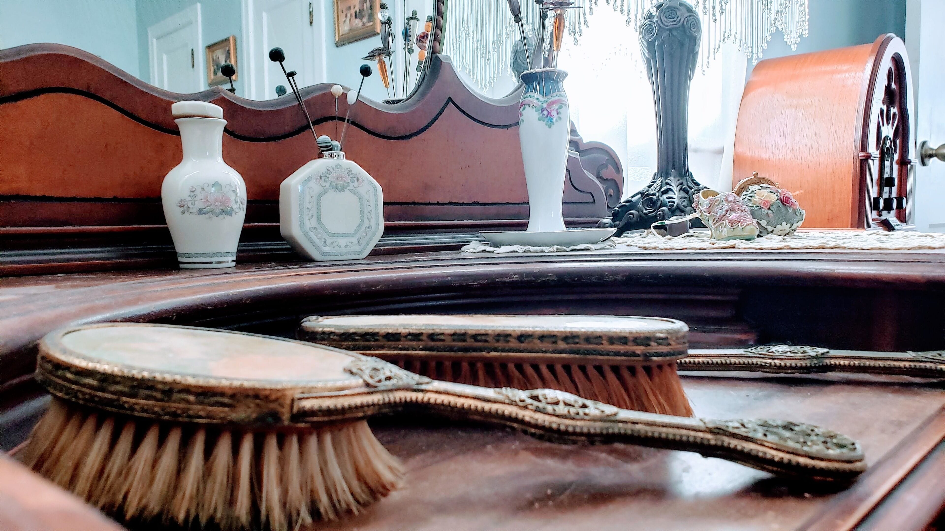 A wooden bed with ornate carvings and a brass bed frame.