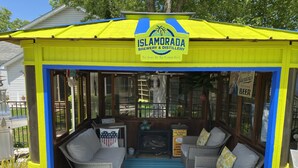 Un área de estar al aire libre techada con un letrero que dice 'Isladora Brewery & Distillery'.