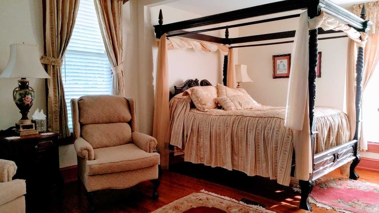 A four-poster canopy bed with a wooden frame and a canopy.