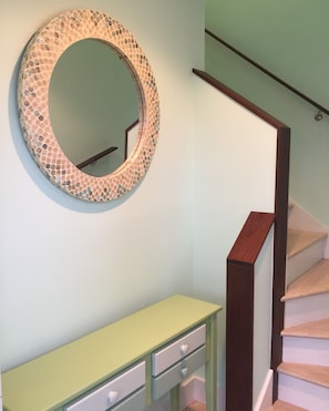 A staircase with a wooden handrail and a light green wall.