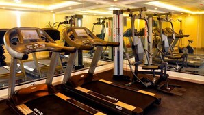 A gym with cardio machines, weight machines, and a mirrored wall. - Jubail Inn (Al Jubail)