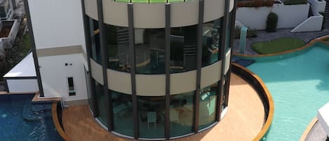 A modern building with a circular pool and a rooftop garden.