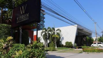 A modern hotel entrance with a prominent sign reading "WISDOM HOTEL & RESIDENCE".