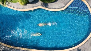 Una piscina al aire libre, sillones reclinables de piscina