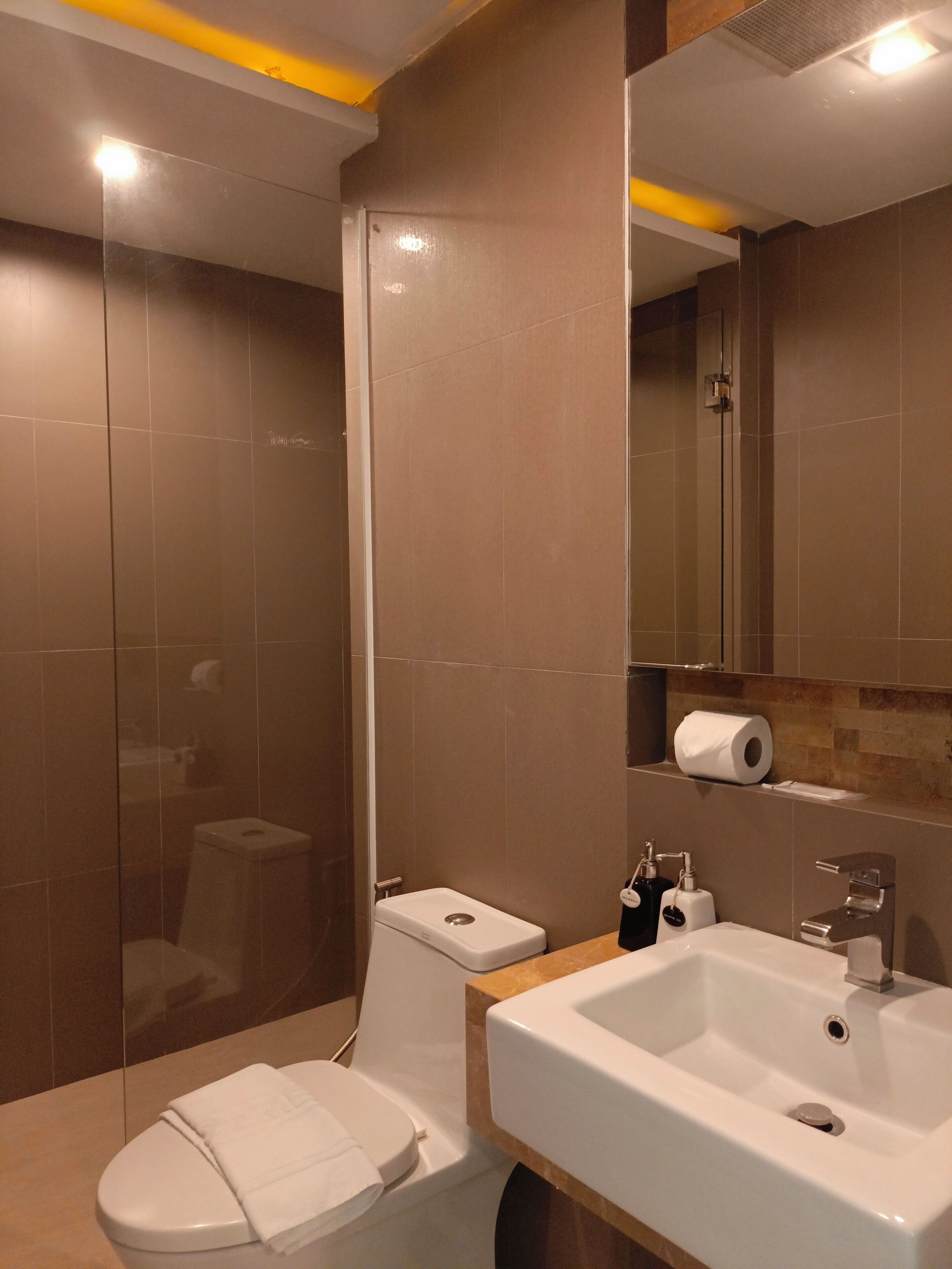 Un baño moderno con inodoro, lavamanos y ducha.