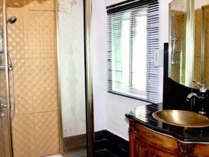 A bathroom with a bathtub, a sink with a gold basin, and a window with blinds. - The Residence Apartments (Lagos)