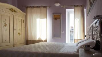 A bedroom with a bed, a dresser, a mirror, and a window with curtains.