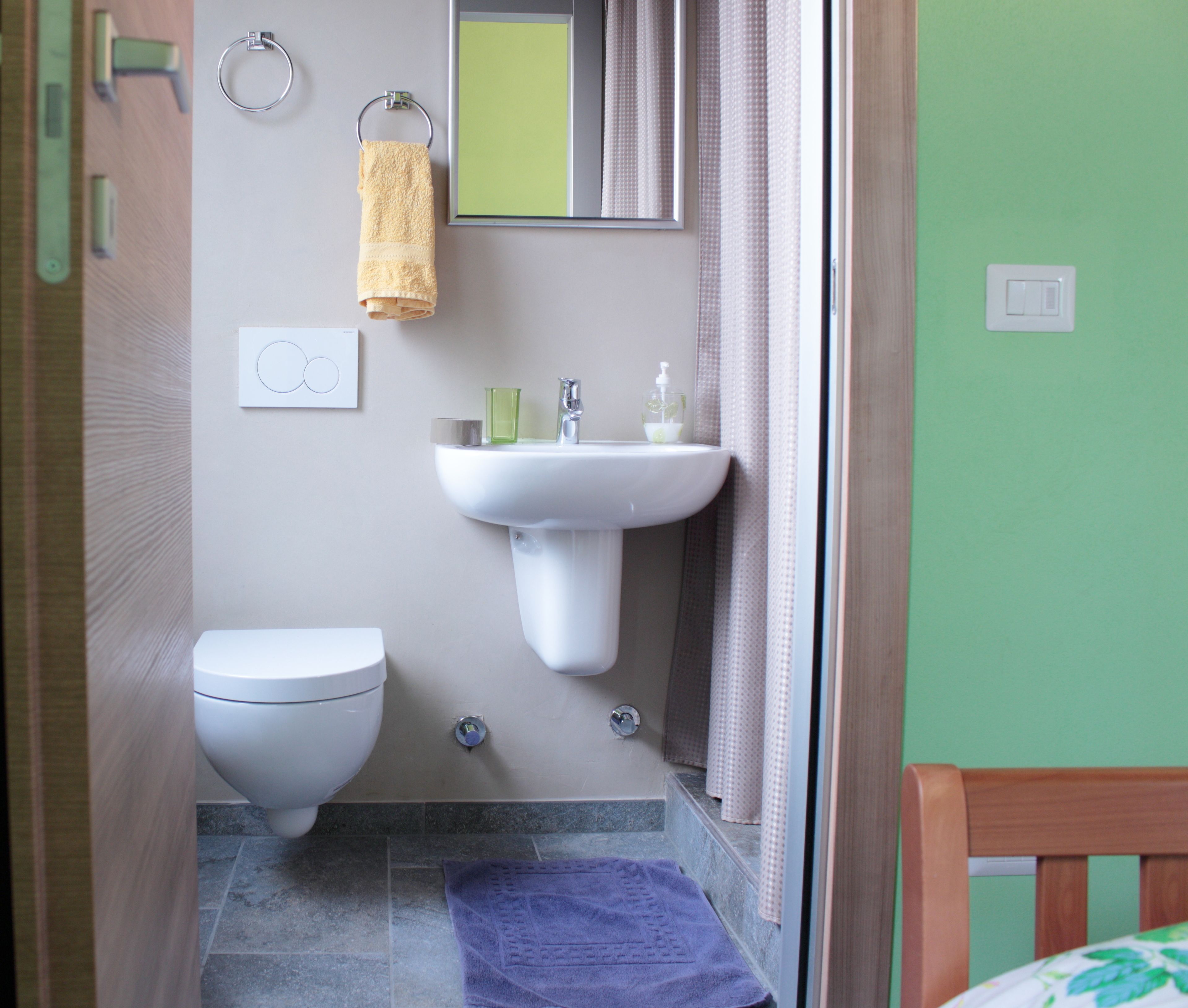 Ein Badezimmer mit Toilette, Waschbecken und Spiegel.