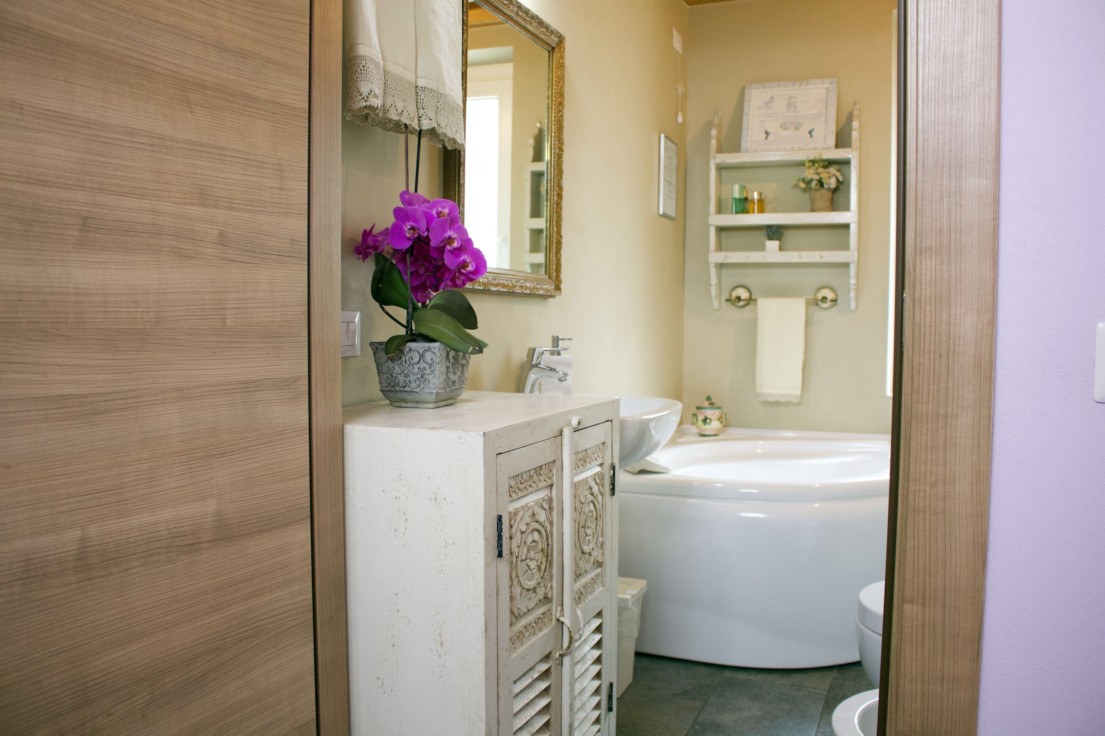 A bathroom with a white sink, a large bathtub, and a mirror above the sink.
