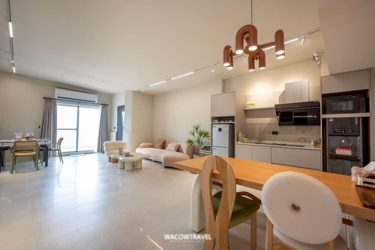 A modern apartment with a dining area, kitchen, and living space.