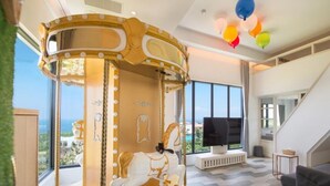 Un salon moderne avec un carrousel, de grandes fenêtres et un téléviseur à écran plat.