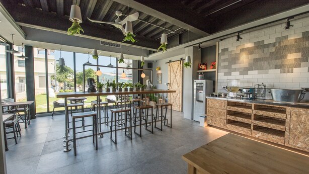 Une cuisine moderne dotée d’un bar, de grandes fenêtres et offrant une vue sur l’extérieur.