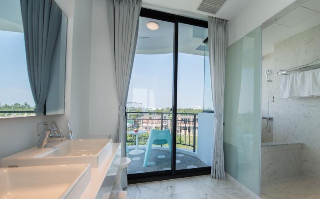 Un baño moderno con una ventana grande, una bañera, una ducha y un inodoro.