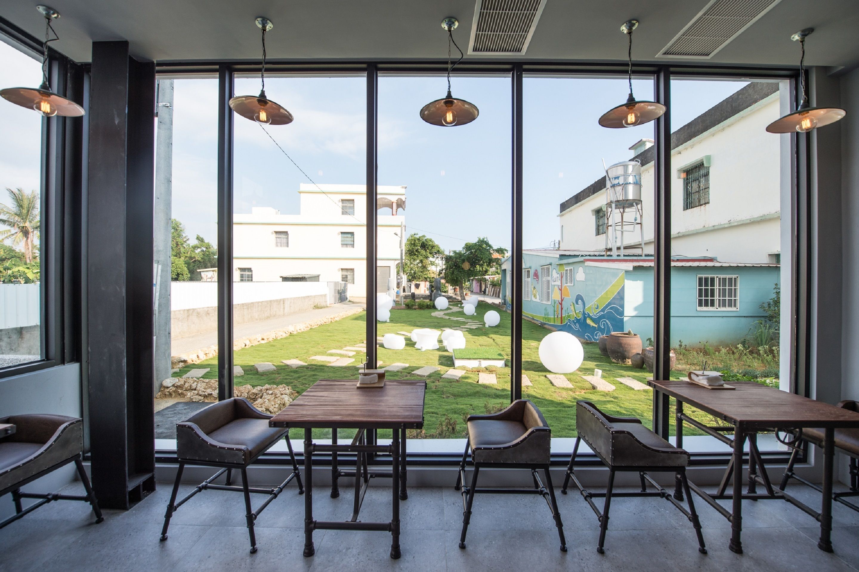 Een modern interieur met grote ramen, houten tafels en leren stoelen.