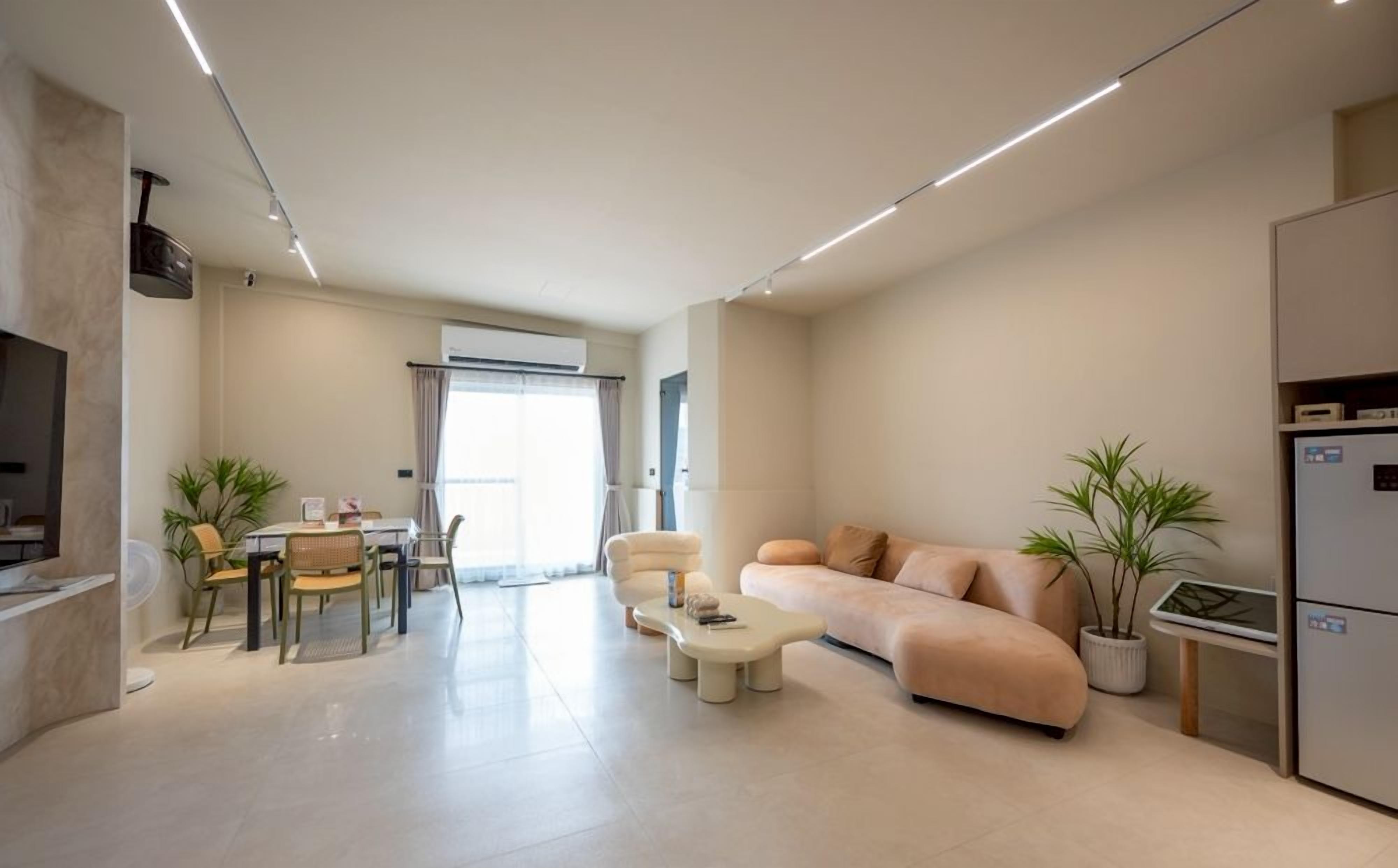 A modern living room with a sofa, coffee table, and dining area.