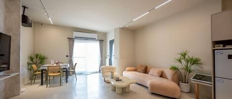 A modern living room with a sofa, coffee table, and dining area.