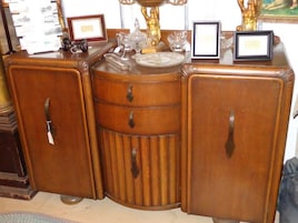 Un mueble de madera con tres cajones y dos puertas, con tiradores metálicos.