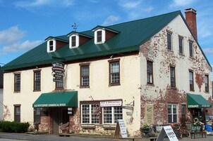 Un edificio antiguo con techo verde, con letreros que dicen 'Old Winterport Commercial House' y 'Antiques'.